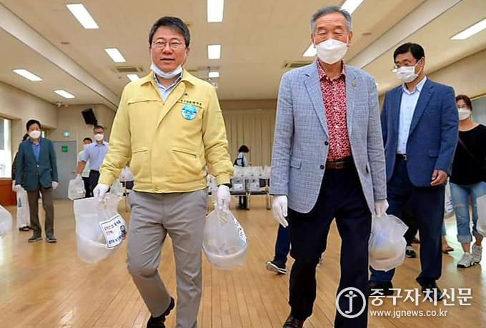 서양호 구청장과 하태성 주민자치위원장 등이 어르신께 삼계탕을 배달하기 위해 주민들과 황학동 주민센터 강당을 나서고 있다.