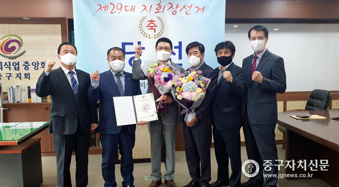 한국외식업중앙회 제29대 중구지회장으로 당선된 신현수 후보가 꽃다발을 받은 뒤 선거관계자들과 기념촬영을 하고 있다.
