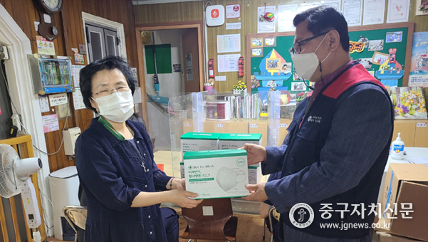 지난 22일 문기식 회장이 김경일 파란마음 주간보호센터장에게 마스크를 전달하고 있다.