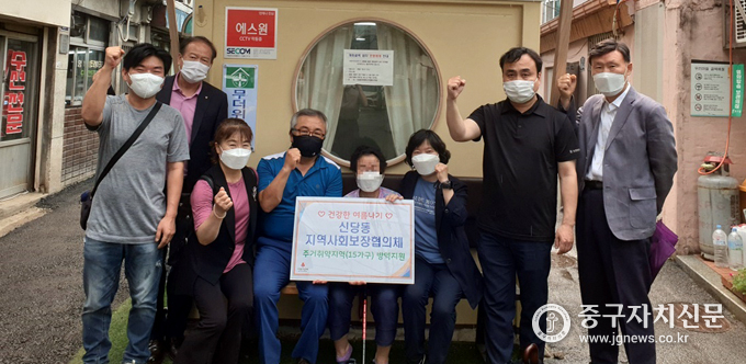 신당동 지역사회보장협의체에서 초복맞이 삼계탕 대접을 위해 포장된 삼계탕 앞에서 기념촬영을 하고 있다.