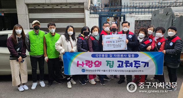 신당동에서 사랑의 집 고쳐주기를 마친 문기식 회장등이 관계자들과 기념촬영을 하고 있다. 