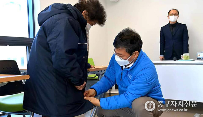 서양호 구청장이 어르신에게 방한복을 입혀드리고 있다.