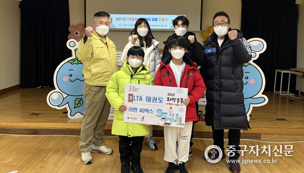 LTA태권도의 이호철 관장과 학생들이 소외된 이웃을 위해 활용해 성품을 전달한 뒤 파이팅을 하고 있다. 