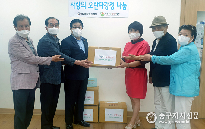 지난 13일 백항선(우측 세번째) 회장이 박한성(좌측 세번째) 회장에게 사랑의 강정을 전달하고 있다.