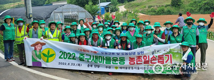 2022 중구새마을운동 농촌일손돕기 현수막 앞에서 단체 기념촬영을 하고 있다.