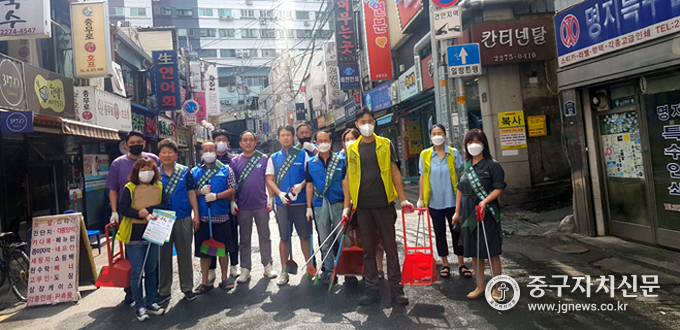 충무로 골목형 상점가 상인들이 청소를 한 뒤 포즈를 취하고 있다.