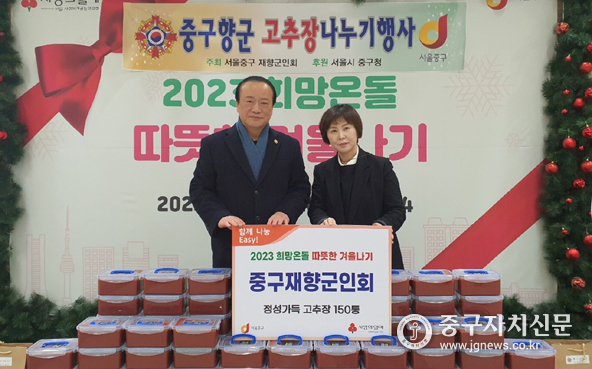 김영주 중구향군 회장이 중구광장에서 이수정 복지지원과장에게 고추장을 전달하고 있다.