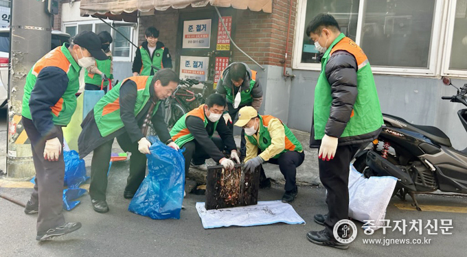 다산동 자율방재단 단원들이 빗물받이 대청소를 실시하고 있다. 