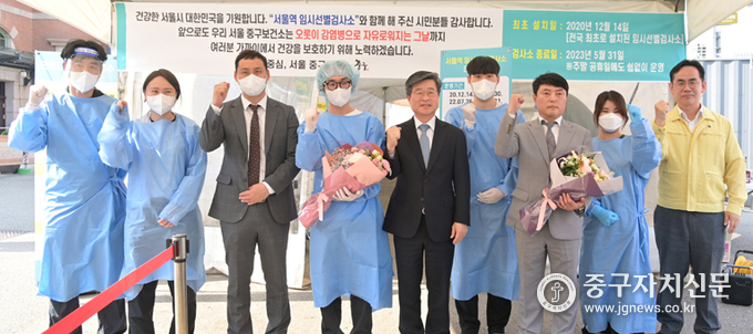 김길성 중구청장은 서울역 임시선별 검사소 운영 종료를 앞두고 근무자에게 꽃다발을 전달하고 파이팅을 하고 있다.