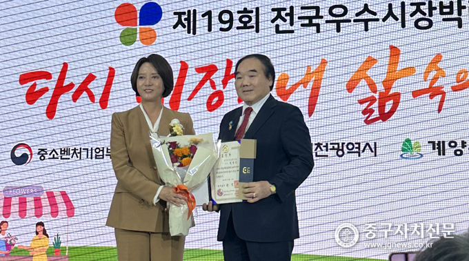 김정안 회장이 제19회 전국 우수시장 박람회 ‘K-마켓 페어’에서 국무총리 표창장을 받고 있다.