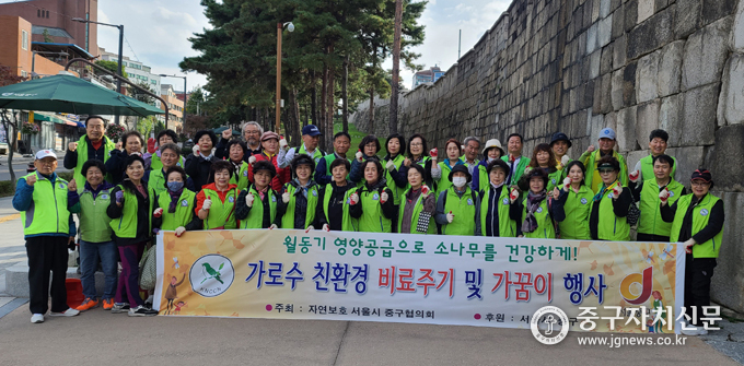 자연보호중구협의회 회원들이 소나무에 친환경 막걸리를 준 뒤 파이팅을 하고 있다.
