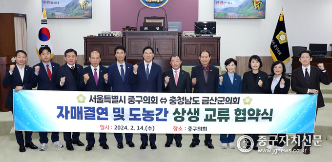 중구의회 본회의장에서 중구의회 의원들이 금산군의회 의원들과 파이팅을 하고 있다.