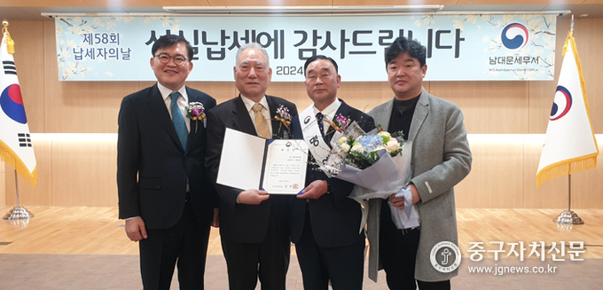 김상구 남대문세무서장이 유재근 일일명예서장에게 위촉장을 수여한 뒤 관계자들과 함께 기념촬영을 하고 있다. 