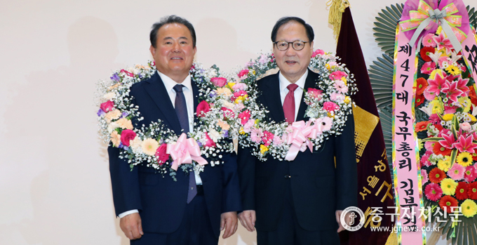중구상공회장 이·취임식에서 이창환 회장과 김한술 직전 회장이 축하 꽃다발을 받고 기념촬영을 하고 있다. 