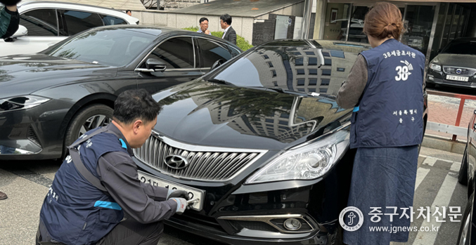 중구청 체납차량 단속반이 체납차량에 대한 번호판을 영치하고 있다.