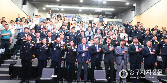 의용소방대원들과 내빈들이 경건한 마음으로 국기에 대한 경례를 하고 있다.