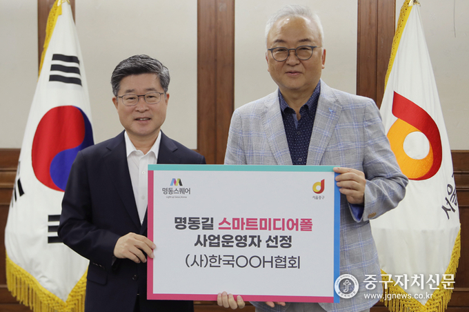지난 8월 22일 착수보고회에서 김길성 중구청장(좌)과 우창훈 회장(우)이 사업자운영을 선정한 뒤 기념촬영을 하고 있다.
