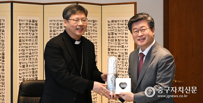 정순택 대주교(좌)와 김길성 중구청장(우)이 상호 기념품을 교환하고 있다.
