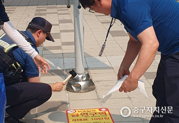 서울역 광장의 금연구역지정을 알리는 스티커를 부착하고 있다.