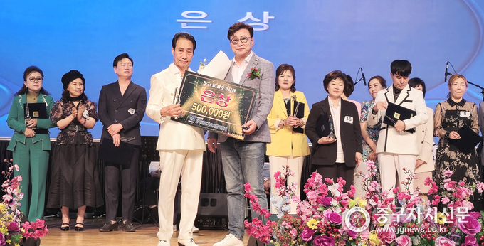  제26회 배호가요제에서 이정오씨가 윤천금 심사위원으로부터 은상을 수상하고 있다.