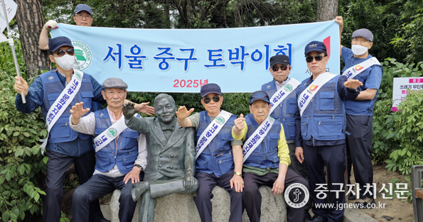 정동기 중구토박이 회장과 임원들이 장소팔 동상에서 단체촬영을 하고 있다.