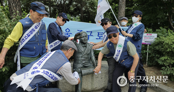 정동기 중구토박이 회장과 임원들이 장소팔 동상을 청소하고 있다.