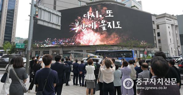 명동스퀘어에 상영된 부안군 홍보 영상을 관심있게 지켜보고 있다.