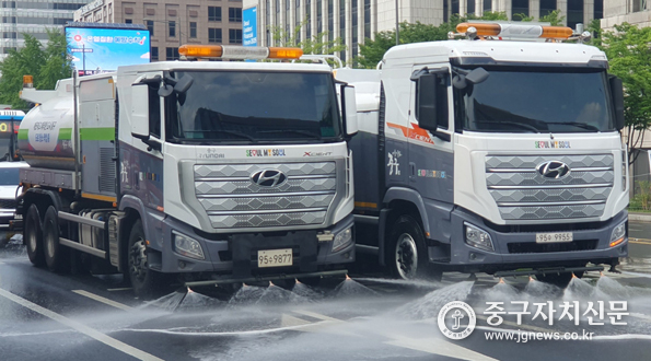 무더운 여름 살수차가 도로에 물을 뿌려 온도를 낮추고 있다. 