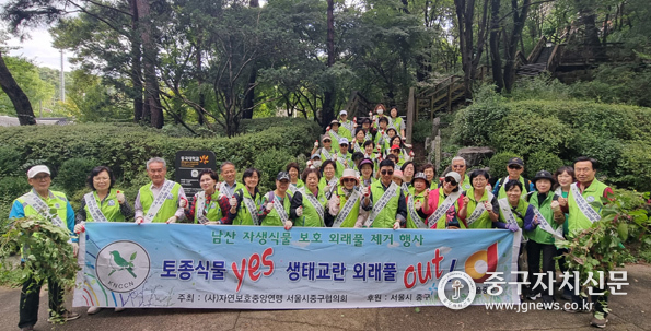 자연보호중구협의회 회원들이 남산에서 외래풀을 제거한 후 파이팅을 하고 있다.