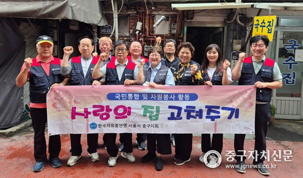 한국자유총연맹 즁규지회가 사랑의 집 고쳐주기 사업을 진행한 후 기념촬영을 하고 있다.